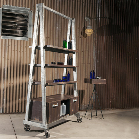 Fast Rattler is an American Industrial style double sided retail shelving, storage and display unit.  Shown in a rustic salon with a Rip Rap retail table.  Galvanized frame and Wenge Saw Cut finish.