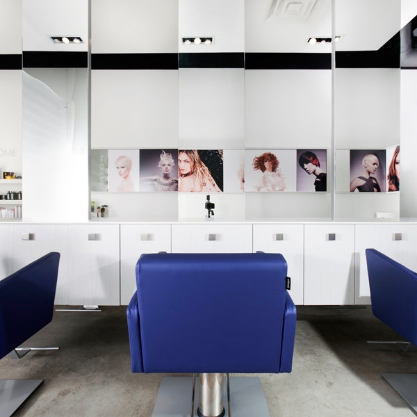 Station cabinets are supported by steel legs and a welded steel frame with a powder coat finish. Mirrors come with safety backer and polished edges. Shown in white/silver finish with a blue Facet styling chair.