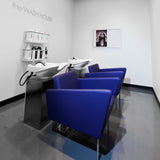 Facet Wash is a clean modern shampoo station for your salon.  Two wash stations with chairs shown in blue synthetic leather with silver legs and white shampoo sinks.